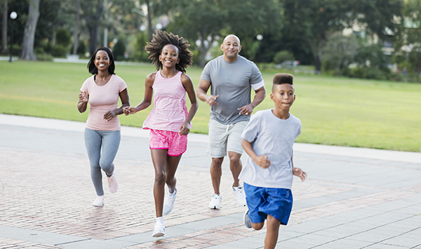 Interracial family running in park together