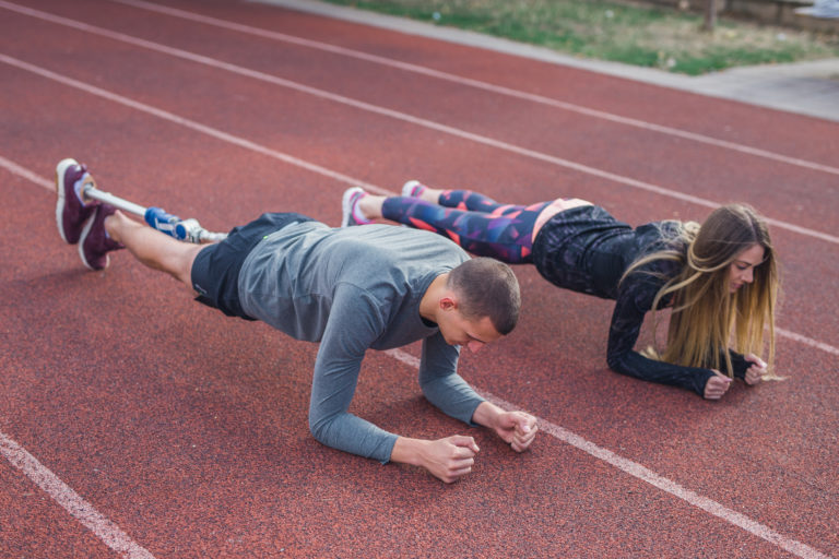  young sports couple on a plank position.