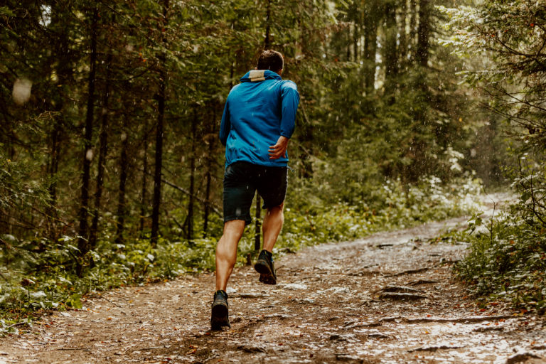 fast running athlete runner forest trail under rain